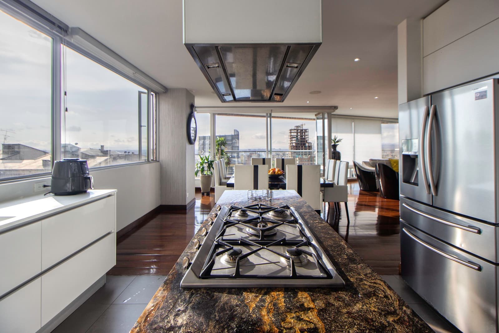 An air fryer on a kitchen counter beside a bowl of crisp food